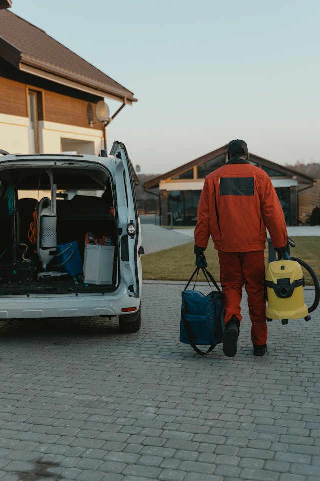 Op de foto zie je een schoonmaak werkbus staan waarbij een werknemer van Limburgschoon de poetsspullen uithaalt